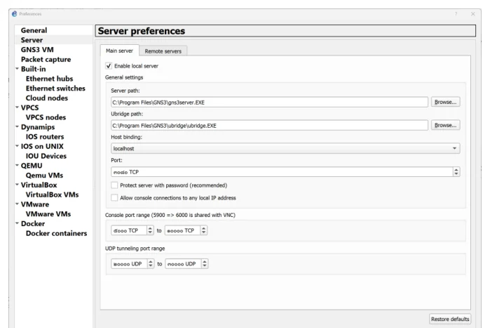 หน้าต่าง Preferences ของ GNS3 แถบซ้ายเป็นรายการหมวดตั้งค่า General, Server, GNS3 VM, Packet capture, Built-in ที่มี Ethernet hubs, Ethernet switches, Cloud nodes, VPCS, Dynamips ที่มี IOS routers, IOS on UNIX ที่มี IOU Devices, QEMU, VirtualBox, VMware และ Docker โดยเลือก Server อยู่ ด้านขวาหัวข้อ Server preferences มีสองแท็บคือ Main server และ Remote servers กำลังอยู่แท็บ Main server มีช่องติ๊ก Enable local server ติ๊กอยู่ พร้อมช่อง Server path และ Ubridge path ที่ชี้ไปยังพาธแบบ C ไดรฟ์ Program Files GNS3 ช่อง Host binding เป็น localhost ช่อง Port และช่วง Console port range 5900 ถึง 6000 กับ UDP tunneling port range