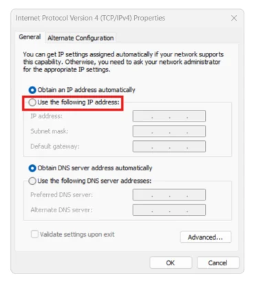กล่องโต้ตอบ Internet Protocol Version 4 TCP/IPv4 Properties ของ Windows มีสองแท็บคือ General และ Alternate Configuration ข้อความอธิบายว่าสามารถรับค่า IP อัตโนมัติได้ถ้าเครือข่ายรองรับ ด้านล่างมีปุ่มตัวเลือกสองอันคือ Obtain an IP address automatically ที่ถูกเลือกอยู่ และ Use the following IP address ซึ่งมีกรอบสีแดงล้อมรอบ ใต้ลงมามีช่อง IP address, Subnet mask และ Default gateway ที่จางอยู่เพราะยังไม่ได้เลือก ถัดลงมาเป็นตัวเลือก DNS สองอันและช่อง Preferred DNS server กับ Alternate DNS server ที่จางเช่นกัน ด้านล่างมีปุ่ม Advanced, OK และ Cancel