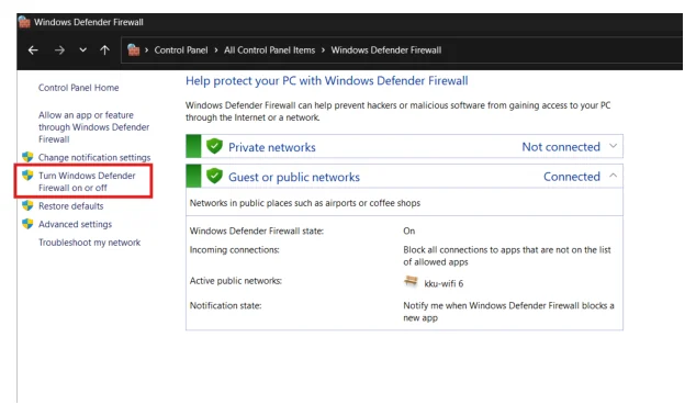 หน้า Windows Defender Firewall ของ Windows หัวข้อว่า Help protect your PC with Windows Defender Firewall แถบซ้ายมีลิงก์ Control Panel Home, Allow an app or feature through Windows Defender Firewall, Change notification settings, Turn Windows Defender Firewall on or off ที่มีกรอบสีแดงล้อมรอบ, Restore defaults, Advanced settings และ Troubleshoot my network ด้านขวามีสองแถบ แถบ Private networks สถานะ Not connected และแถบ Guest or public networks สถานะ Connected ที่กางออกแสดงรายละเอียดว่า Windows Defender Firewall state เป็น On, Incoming connections บล็อกทุกแอปที่ไม่ได้อยู่ในรายการอนุญาต, Active public networks คือ kku-wifi 6 และ Notification state