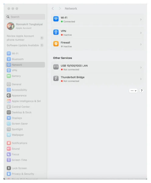 หน้าต่าง System Settings ของ macOS แถบซ้ายเป็นรายการหมวดตั้งค่าพร้อมช่องค้นหาและชื่อบัญชี Apple ด้านบน ตามด้วยรายการ Wi-Fi, Bluetooth, Network ที่ถูกเลือกอยู่, VPN, Battery, General, Accessibility, Appearance, Apple Intelligence และ Siri, Control Center, Desktop และ Dock, Displays, Screen Saver, Spotlight, Wallpaper, Notifications, Sound, Focus, Screen Time, Lock Screen, Privacy และ Security ด้านขวาเป็นหน้า Network มีสามแถวบนคือ Wi-Fi สถานะ Connected จุดเขียว, VPN สถานะ Inactive และ Firewall สถานะ Inactive จุดส้ม ถัดลงมาเป็นหัวข้อ Other Services มีสองแถวคือ USB 10/100/1000 LAN สถานะ Not connected จุดแดง และ Thunderbolt Bridge สถานะ Not connected