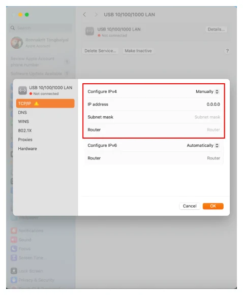 แผ่นโต้ตอบที่เลื่อนลงมาทับหน้าต่าง System Settings ที่จางอยู่ด้านหลัง ด้านซ้ายของแผ่นเป็นรายการหมวดคือ USB 10/100/1000 LAN, TCP/IP ที่ถูกเลือกเป็นแถบสีส้มและมีไอคอนสามเหลี่ยมเตือน, DNS, WINS, 802.1X, Proxies และ Hardware ด้านขวามีกรอบสีแดงล้อมสี่แถวบน ได้แก่ Configure IPv4 เป็นดรอปดาวน์ตั้งค่าไว้ที่ Manually, IP address แสดงค่า 0.0.0.0, Subnet mask เป็นช่องว่างที่มีข้อความจาง ๆ ว่า Subnet mask และ Router เป็นช่องว่างที่มีข้อความจาง ๆ ว่า Router ถัดลงมาเป็น Configure IPv6 ตั้งค่าไว้ที่ Automatically และแถว Router ของ IPv6 ด้านล่างขวามีปุ่ม Cancel และปุ่ม OK สีส้ม